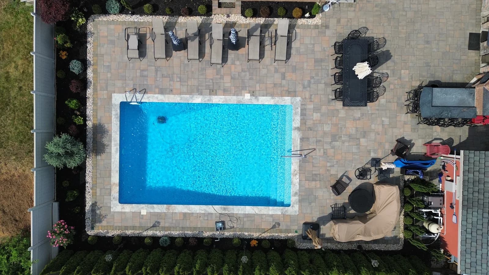 Aerial drone view of a completed Father & Sons masonry project in New Jersey, paver hardscaping around the home