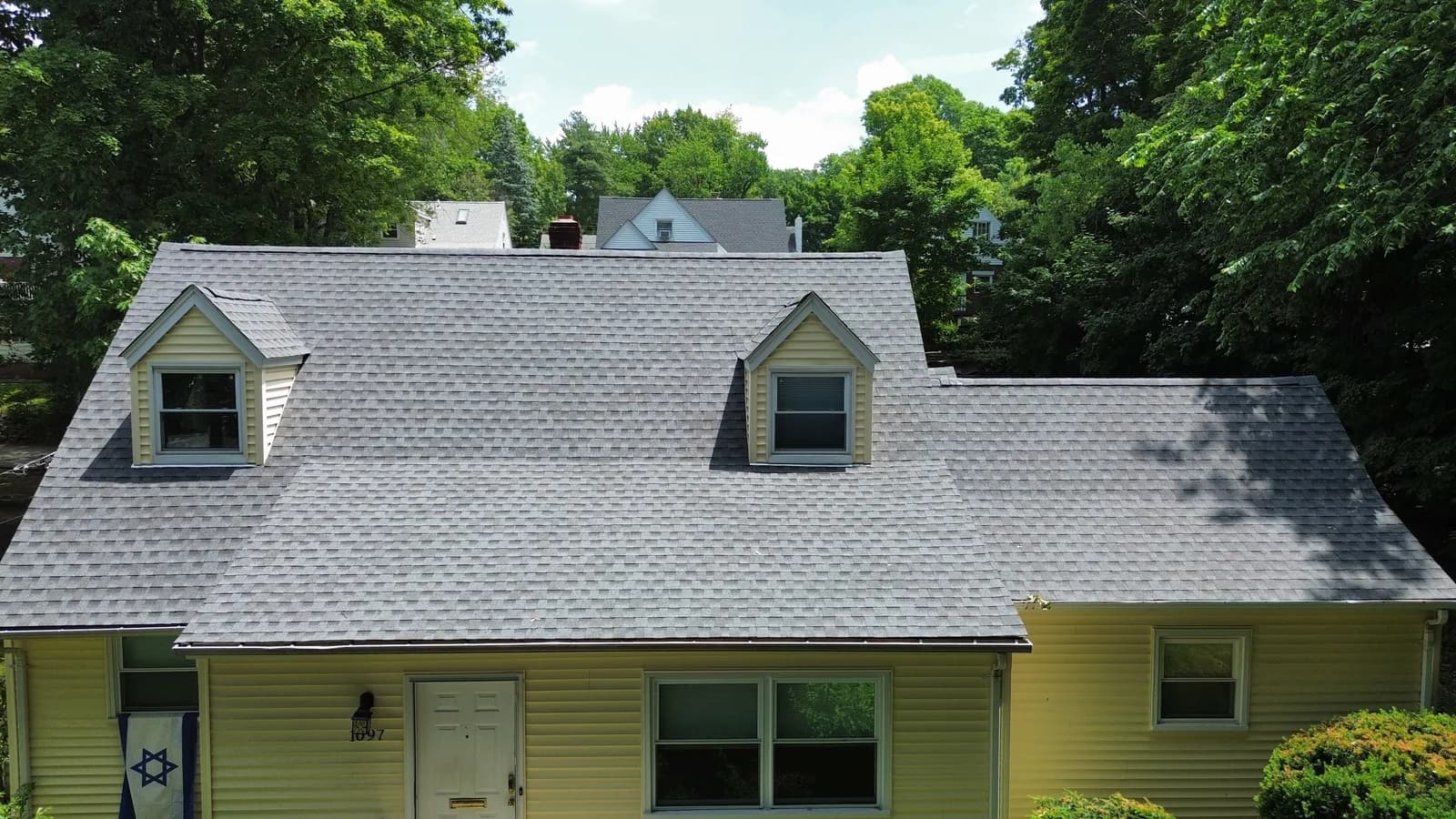 Top-down drone view of a finished gray shingle roof in New Jersey