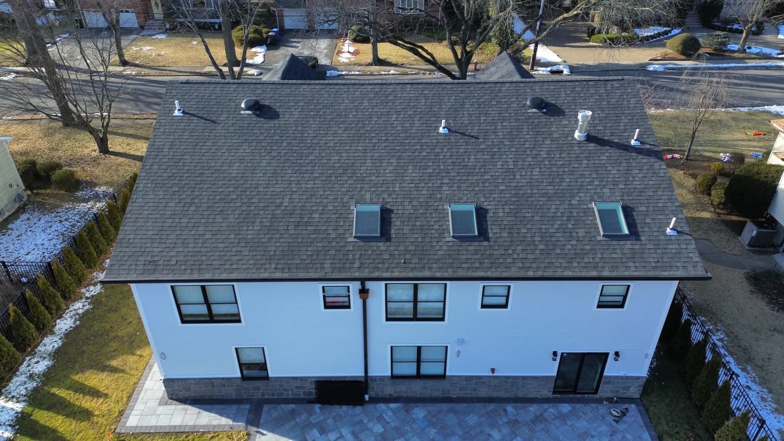 Aerial view of a NJ roof with a row of skylights installed along the rear slope