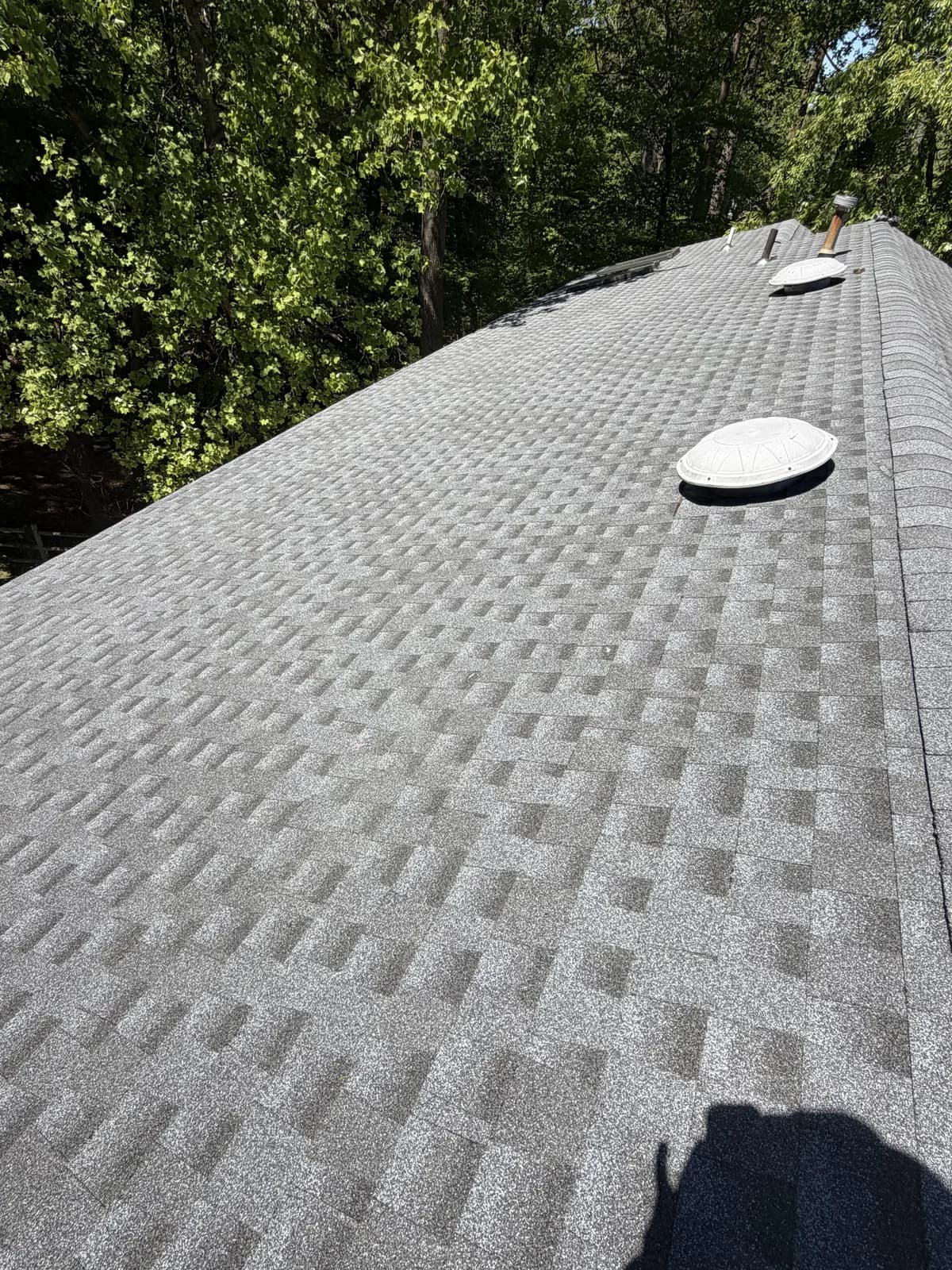 Finished shingle roof in NJ with a skylight and roof vents properly flashed in